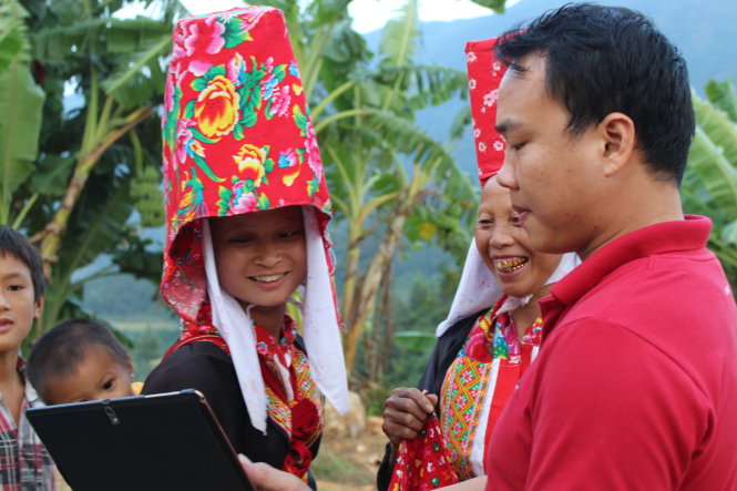 Phụ nữ Dao Thanh Phán với chiếc mũ độc đáo thích thú xem lại ảnh do du khách chụp - Ảnh: Nguyễn Hường