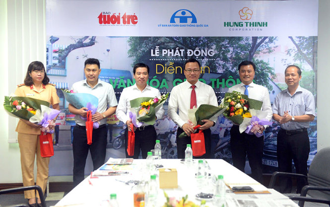 Ông Lê Xuân Trung – Phó TBT báo Tuổi Trẻ trao hoa cho các khách mời tham gia diễn đàn Văn hoá giao thông - Ảnh: HỮU KHOA