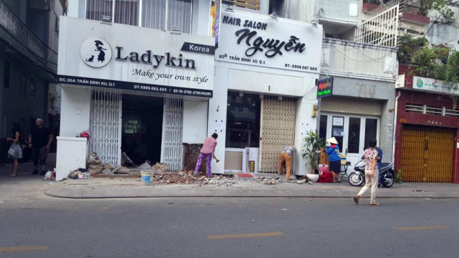 Hai nhà 85A, 85B Trần Đình Xu, phường Nguyễn Cư Trinh đã thuê người tháo dỡ bậc tam cấp đặt trên vỉa hè vào sáng 26-2. Ảnh: TP