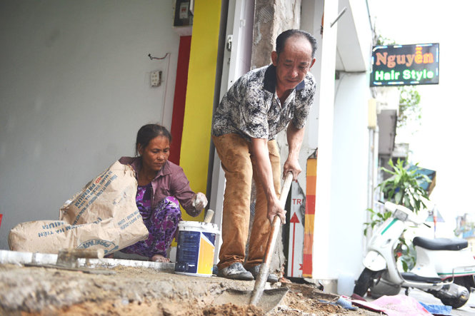 Một số hộ dân tại đường Trần Đình Xu đã thuê người tháo dỡ phần công trình lấn chiếm vỉa hè sau khi nhận thông báo của cơ quan chức năng  - Ảnh: LÊ PHAN