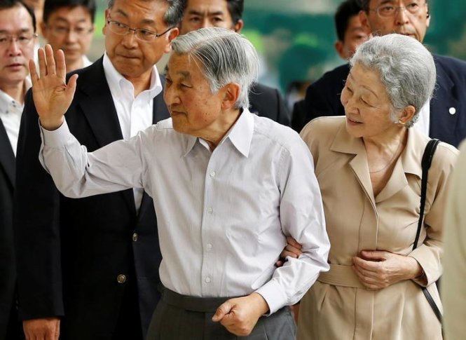 Nhật hoàng Akihito và vợ ông giơ tay chào người dân khi lên tàu cao tốc Shinkansen để về khu biệt thử nghỉ dưỡng mùa hè của hoàng gia tại Nasu ở Tokyo, Nhật Bản ngày 25-7-2016 - Ảnh: Reuters
