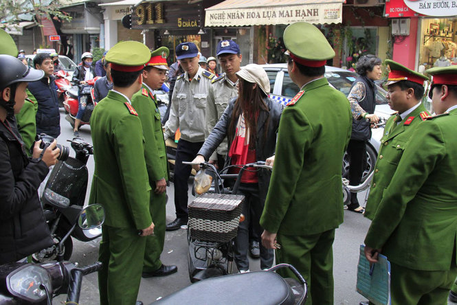 Ngày 27-2, lực lượng công an, dân phòng quận Hoàn Kiếm đã kiểm tra, xử phạt nhiều trường hợp lấn chiếm vỉa hè trên địa bàn quận Hoàn Kiếm - Ảnh: XUÂN THÀNH