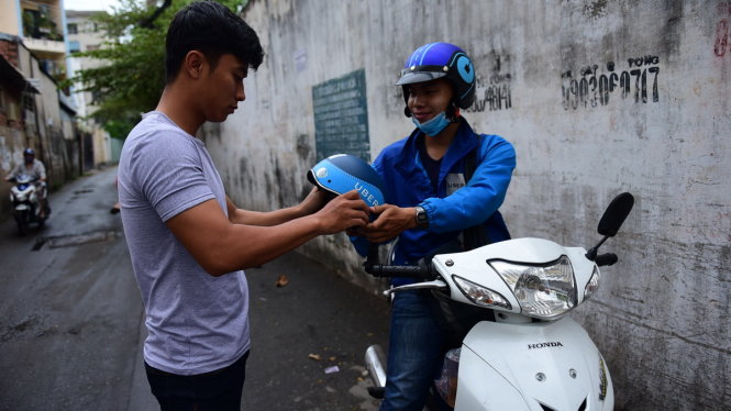 Một tài xế Uber đón khách trên đường Nơ Trang Long, Q. Bình Thạnh, TP.HCM - Ảnh: HỮU THUẬN