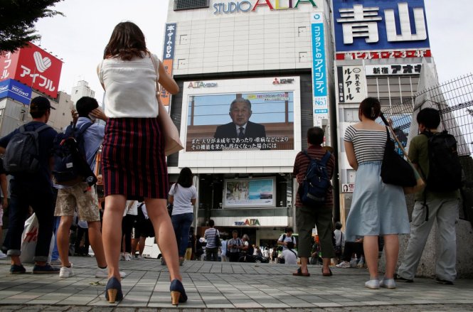 Người dân Nhật Bản theo dõi bài phát biểu của Nhật hoàng trên truyền hình vào tháng 8-2016 - Ảnh: Reuters