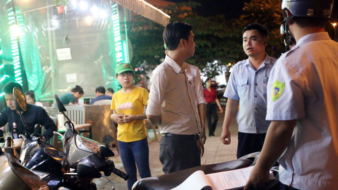Lực lượng chức năng lập biên bản, xử lý một quán nhậu lấn chiếm vỉa hè trên đường Phạm Văn Đồng - Ảnh: Tâm Đức