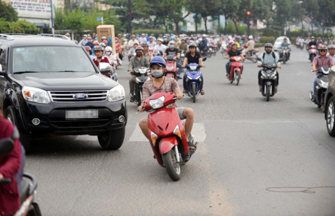 Một chiếc xe máy “cúp đầu” ôtô trên đường Trường Chinh, Q.Tân Bình, TP.HCM - Ảnh: HỮU KHOA