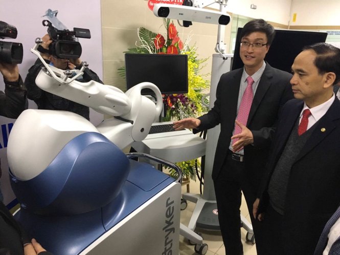 Bác sĩ Hoàng Gia Du, trưởng khoa chấn thương chỉnh hình và cột sống, Bệnh viện Bạch Mai, đang giới thiệu hệ thống robot hỗ trợ phẫu thuật - Ảnh: Thuý Anh