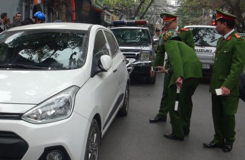 Công an niêm phong xe đậu dưới lòng đường ở quận Hoàn Kiếm, Hà Nội - Ảnh: Dương Liễu