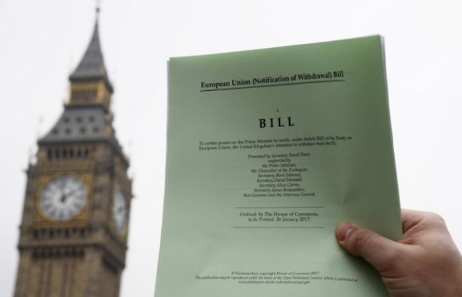 Một nhà báo chìa ra một bản sao của dự luật Brexit trước tòa nhà quốc hội ở London, Anh ngày 26-1-2017 - Ảnh: Reuters