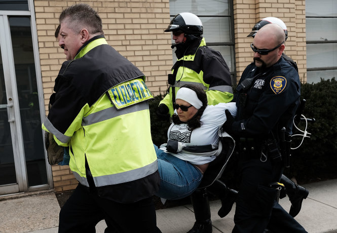 Cảnh sát bang New Jersey bắt giữ một người biểu tình phản đối sắc lệnh về nhập cư của Tổng thống Trump hôm 23-2  - Ảnh: AFP