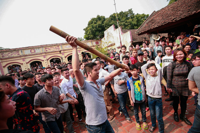 Sau hơn 1 tiếng đồng hồ, khúc tre đã được đưa lên khỏi đám đông và được một thanh niên đưa vào trong đình