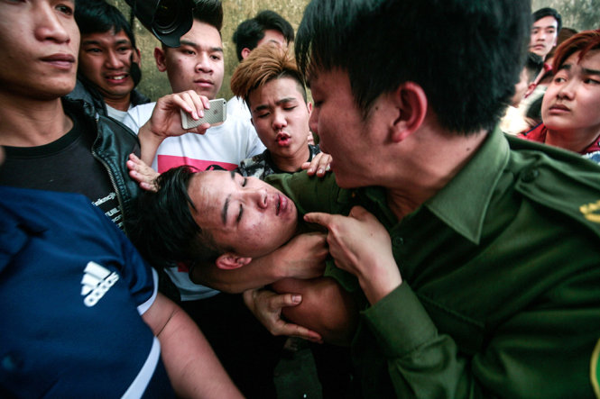 Lực lượng an ninh khống chế một thanh niên quá khích gây gổ - Ảnh: NAM TRẦN