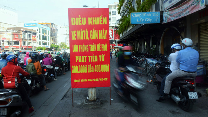 Biển cảnh báo xử phạt khi đi xe máy, ô tô lên vỉa hè trên đường Nguyễn Văn Cừ, Q.1 - Ảnh: HỮU KHOA