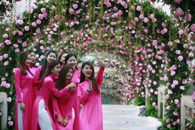 Các bạn trẻ chụp ảnh tại cổng hoa hồng - Ảnh: Nam Trần