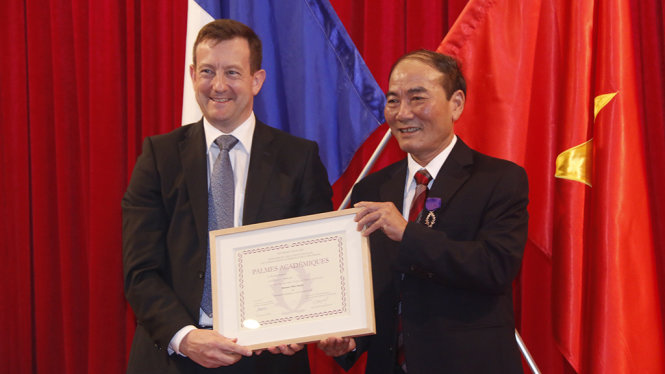 Đại sứ Pháp tại VN Bertrand Lortholary trao huân chương cho ông Nguyễn Nhiên (phải) - Ảnh: THÁI LỘC