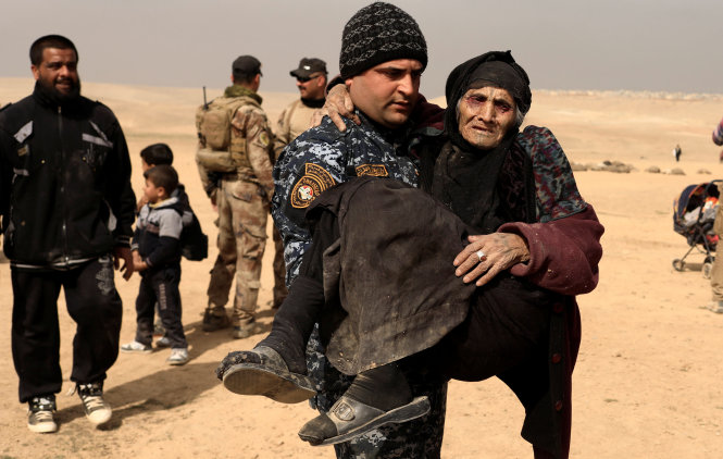 Binh lính Iraq sơ tán một thường dân khỏi khu vực tây Mosul, ngày 27-2 - Ảnh: Reuters