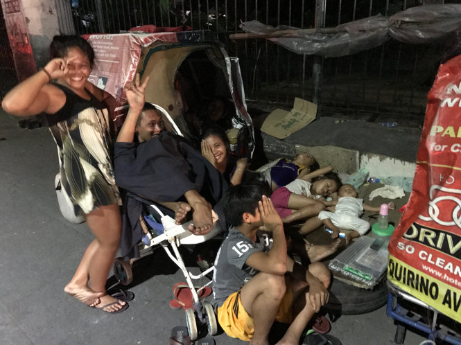 Một gia đình nhiều thành viên sống trên vỉa hè ở khu Barangay, thủ đô Manila. Họ hồn nhiên khi được chụp ảnh - Ảnh: QUỲNH TRUNG