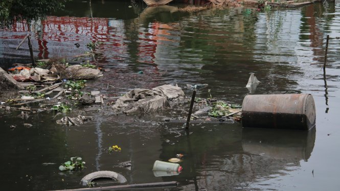 Nước hồ Tây ở gần khu vực nhà hàng có màu đen sẫm kiểu ao tù ô nhiễm, phía trên mặt nước rác thải sinh hoạt nổi lềnh bềnh - Ảnh: Danh Trọng