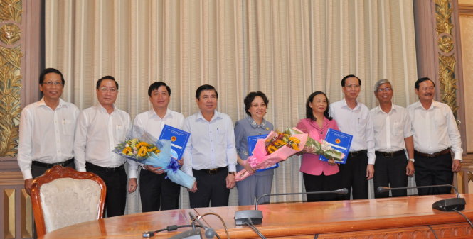 Chủ tịch UBND TP.HCM Nguyễn Thành Phong trao Quyết định và hoa chúc mừng lãnh đạo Ban Quản lý An toàn thực phẩm TP.HCM - Ảnh: Xuân Đặng