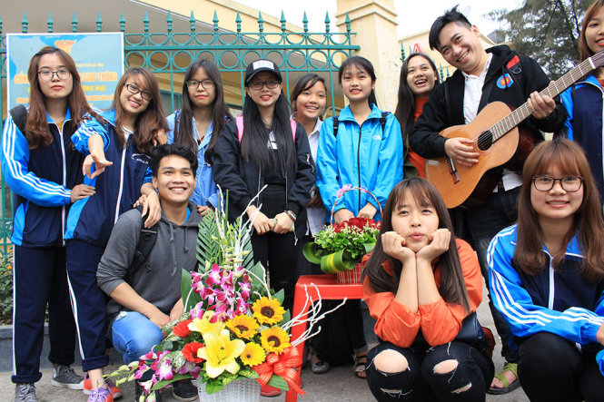 Nhóm bạn trẻ CLB 25 Hoàng Hà bán hoa gây quỹ tại cổng trường ĐH Thương Mại nhằm giúp các em nhỏ khuyết tật tỉnh Vĩnh Phúc - Ảnh: HÀ THANH