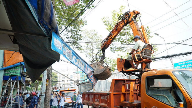 Đoàn liên ngành quận 1 tháo dỡ công trình lấn chiếm vỉa hè trên đường Nguyễn Đình Chiểu P.Đa Kao, Q1 chiều 6-3 - Ảnh: THUẬN THẮNG