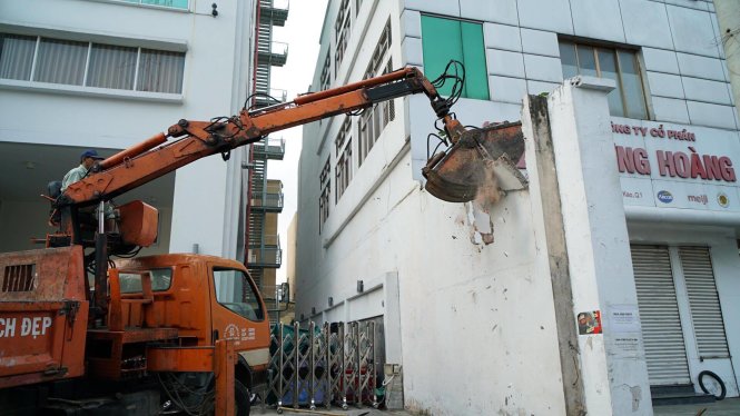 Đoàn kiểm tra đập phá bức tường bên hông tòa nhà Bộ Công thương - Ảnh: THUẬN THẮNG