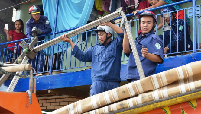 Lực lượng công ích quận 1 tháo dỡ mái che người dân gắn lấn ra vỉa hè đường Nguyễn Đình Chiểu - Ảnh: Lê Phan