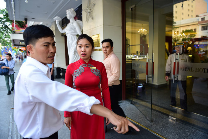 Cán bộ yêu cầu người đại diện của khách sạn Royal trên đường Nguyễn Huệ, Q.1 để xử lý tháo dỡ những bức tượng đá đặt trái quy định trên vỉa hè - Ảnh: HỮU THUẬN