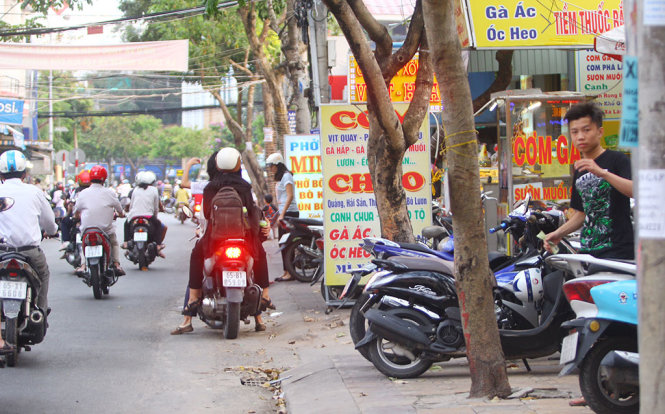 Các quán ăn trên đường Đề Thám (quận Ninh Kiều) đặt biển quảng cáo chiếm hết vỉa hè của người đi bộ - Ảnh: CHÍ QUỐC