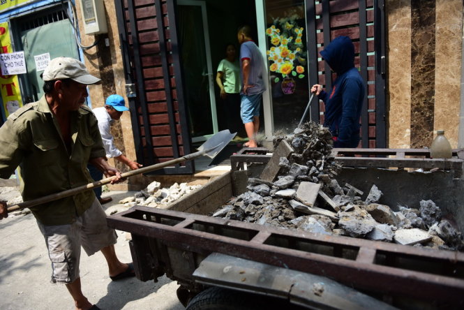 Nhiều nhà dân bị phá dỡ thềm nhà , họ thuê xe chở xà bần để dọn dẹp gạch đá - Ảnh: HỮU THUẬN