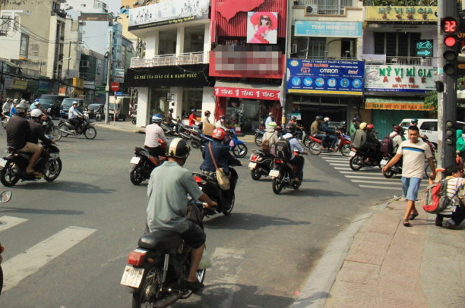 Xe máy trên đường Điện Biên Phủ đến giao lộ Đinh Tiên Hoàng (quận 1) rẽ phải khi đèn đỏ cắt ngang vạch ưu tiên dành cho người đi bộ - Ảnh: SƠN BÌNH