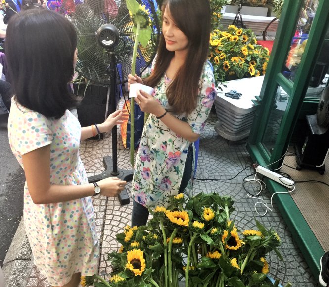 Một bạn nữ mặc áo dài mang hóa đơn mua sách đến để nhận hoa tươi - Ảnh: MINH TRANG
