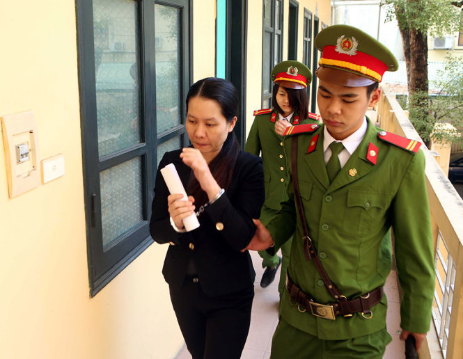 Lực lượng chức năng dẫn giải bị cáo Nguyễn Minh Thu, nguyên tổng giám đốc OceanBank, đến phiên tòa xét xử - Ảnh: TTXVN