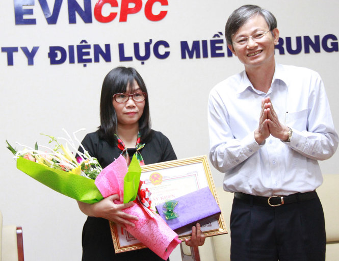 Ông Trần Đình Nhân –Tổng giám đốc Tổng công ty điện lực miền Trung trao thưởng nóng cho chị Trần Thị Anh - Ảnh: ĐOÀN CƯỜNG