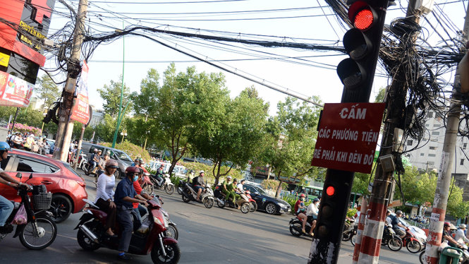 Dù có thêm bảng cấm các phương tiện giao thông rẽ phải khi đèn đỏ nhưng nhiều người đi xe máy từ đường Phạm Văn Hai vẫn rẽ vào đường Trường Sa (Q.Tân Bình, TP.HCM) - Ảnh: Tự Trung