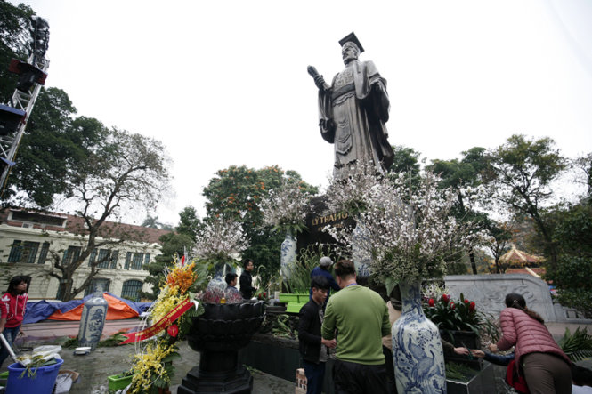 Các công nhân đang tiến hành cắm cành hoa anh đào xung quanh tượng đài vua Lý Thái Tổ