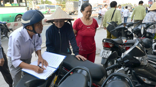 Lực lượng chức năng quận 12 lập biên bản xử phạt một trường hợp buôn bán lấn chiếm vỉa hè - Ảnh: Lê Phan
