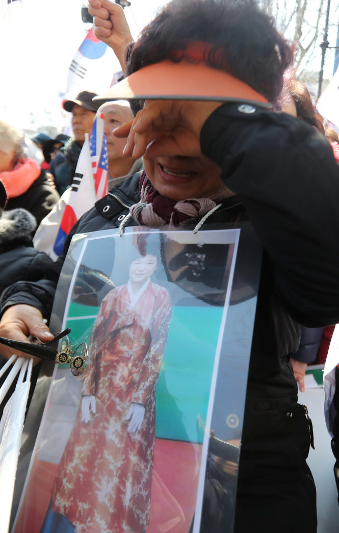Một người dân mang theo bức ảnh chân dung tổng thống Park Geun-hye đã bật khóc nức nở sau khi nghe phán quyết của Tòa án Hiến pháp tại Seoul, Hàn Quốc - Ảnh: Reuters