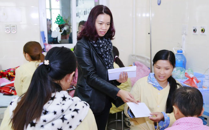 Chị Mai Hoa, vợ ca sĩ Trần Lập, tặng quà từ thiện tại Viện K - Ảnh: MINH TÂM