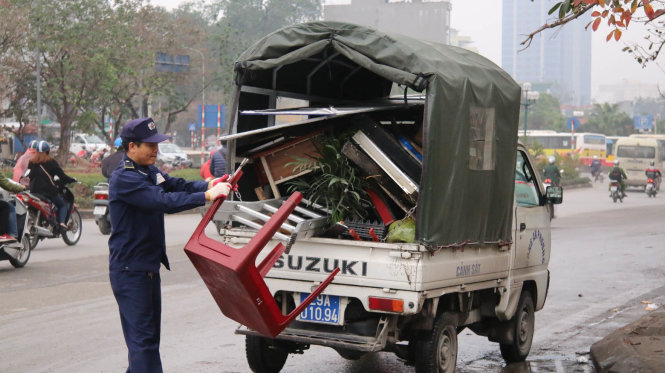 Lực lượng chức năng thu giữ bàn ghế lấn của các hộ kinh doanh lấn chiếm vỉa hè - Ảnh: Danh Trọng