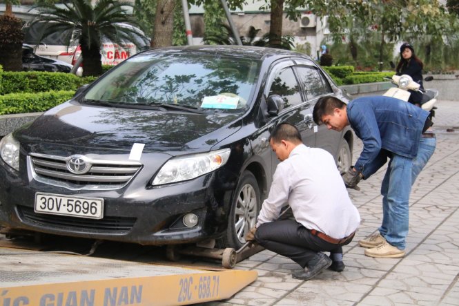 Một chiếc xe ô tô đậu trên vỉa hè bị cẩu về phường để xử lý - Ảnh: Thân Hoàng