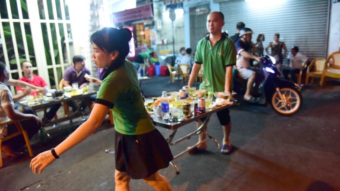 Nhân viên quán ăn  trên đường Cống Quỳnh, Q.1, TP.HCM  bê bàn  ăn vào khi thấy bóng dáng lực lượng trật tự đô thị của phường - Ảnh: Hữu Thuận