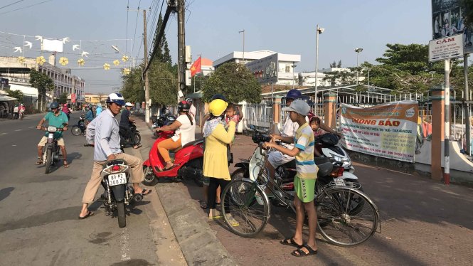 Người dân hiếu kỳ về cái chết của đôi nam nữ trước cổng Nhà văn háo Thiếu nhi tỉnh Sóc Trăng - Ảnh: Khắc Tâm