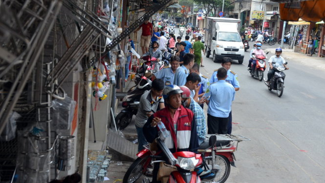 Đoàn kiểm tra xử lý tại đường Sư Vạn Hạnh, đoạn đường này vỉa hè hẹp nhưng bị nhiều người dân buôn bán lấn chiếm - Ảnh: Lê Phan