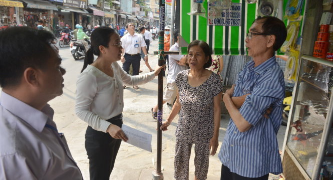 Bà Nguyễn Thị Thu Nga - phó chủ tịch UBND quận 10 làm việc với một hộ dân có mái che xây lấn chiếm trên đường Sư Vạn Hạnh - Ảnh: Lê Phan