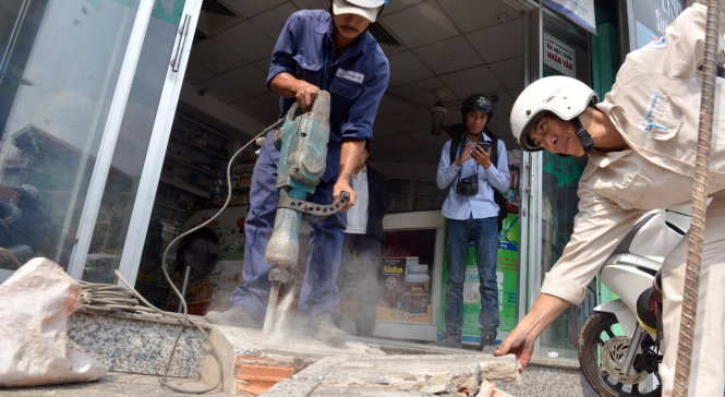 Lực lượng công ích quận 10 tháo dỡ các cầu dân bằng xi măng mà người dân tự xây lấn vỉa hè - Ảnh: Lê Phan