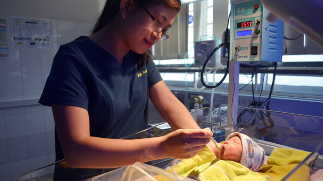 Trai Nhi, em bé sinh non lúc 32 tuần tuổi, được điều dưỡng bón những muỗng sữa hiến tặng từ ngân hàng sữa mẹ - Ảnh: TẤN LỰC