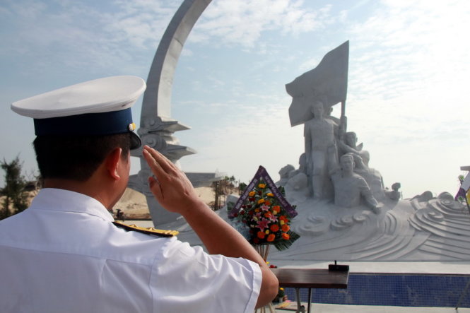 Một cán bộ Lữ 162 Vùng 4 Hải quân thực hiện nghi lễ chào các chiến sĩ hy sinh tại đảo Gạc Ma sau khi dâng hương  - Ảnh: Trung Tân
