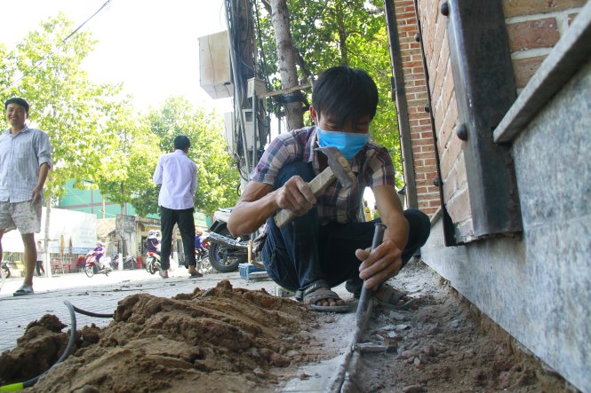 Người dân tự tháo dỡ công trình lấn chiếm vỉa hè - Ảnh: Xuân An