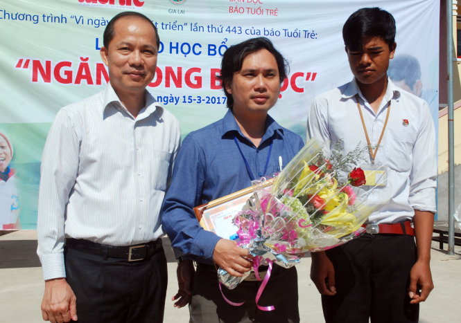 Ông Lê Xuân Trung - phó tổng biên tập báo Tuổi Trẻ, chụp ảnh lưu niệm với thầy Ninh Văn Dậu và em Ksor Gôl tại lễ trao học bổng - Ảnh: B.DŨNG